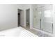 Bright bathroom with bathtub, glass shower, toilet, and doorway to closet at 10742 Cowlite Ave, Las Vegas, NV 89166
