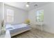 Bright bedroom with ceiling fan, light wood floor, large window, and white desk at 10742 Cowlite Ave, Las Vegas, NV 89166