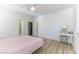 Bright bedroom with ceiling fan, light wood floor, doorway to bathroom, and vanity table at 10742 Cowlite Ave, Las Vegas, NV 89166