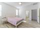 Bright bedroom with ceiling fan, light wood floor, and doorway to bathroom at 10742 Cowlite Ave, Las Vegas, NV 89166