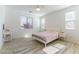 Serene bedroom with light wood floors, multiple windows providing ample natural light, and neutral decor at 10742 Cowlite Ave, Las Vegas, NV 89166