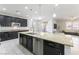 Gourmet kitchen boasting a large granite-topped island with dishwasher, stainless steel appliances, and dark wood cabinets at 10742 Cowlite Ave, Las Vegas, NV 89166