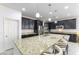 A kitchen with dark cabinets, stainless appliances, and granite counters with a large island and barstool seating at 10742 Cowlite Ave, Las Vegas, NV 89166