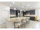 Bright kitchen showcases granite island with seating, stainless appliances, and dark cabinets at 10742 Cowlite Ave, Las Vegas, NV 89166