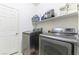 Laundry room with gray washer and dryer, storage shelf, and white door at 10742 Cowlite Ave, Las Vegas, NV 89166