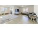 An open living room featuring tile floors, large windows, and sliding glass door access to the patio at 10742 Cowlite Ave, Las Vegas, NV 89166