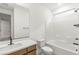 Modern bathroom with dual sinks, tiled floors, and a bathtub with white tiled walls at 10851 Hanwicke Harbor Ave, Las Vegas, NV 89166