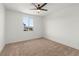 Bedroom with neutral carpet, a ceiling fan, and a large window at 10851 Hanwicke Harbor Ave, Las Vegas, NV 89166