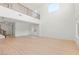 Bright living room with soaring ceilings, balcony overlook, large windows, and wood-look floors at 10851 Hanwicke Harbor Ave, Las Vegas, NV 89166