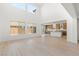 Bright open-concept living room with high ceilings, hardwood floors, and a view of the modern kitchen at 10851 Hanwicke Harbor Ave, Las Vegas, NV 89166