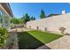 Back yard area featuring decorative rock landscaping and a synthetic grass lawn at 11621 La Mirago Pl, Las Vegas, NV 89138