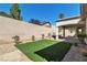 Back yard featuring decorative rock landscaping, a covered patio, and synthetic grass at 11621 La Mirago Pl, Las Vegas, NV 89138