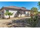 A xeriscaped backyard featuring drought-tolerant landscaping around a charming single-story stucco home with a tiled roof at 11621 La Mirago Pl, Las Vegas, NV 89138