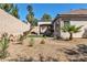Home's backyard featuring a covered patio and drought-resistant landscaping with rock ground cover and desert plants at 11621 La Mirago Pl, Las Vegas, NV 89138