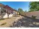 Backyard landscaping with gravel, plants and trees surrounding this single story house with neutral colors at 11621 La Mirago Pl, Las Vegas, NV 89138