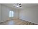 Bright, minimalist bedroom with wood floors, a window, and a ceiling fan at 11621 La Mirago Pl, Las Vegas, NV 89138