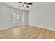 Bright bedroom with wood-look flooring, ceiling fan, and large arched window at 11621 La Mirago Pl, Las Vegas, NV 89138