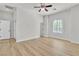 Bright bedroom with wood-look flooring, ceiling fan, and large arched window at 11621 La Mirago Pl, Las Vegas, NV 89138