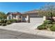 Exterior of a single story home featuring a three car garage, neutral paint, and mature landscaping at 11621 La Mirago Pl, Las Vegas, NV 89138