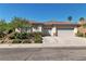 Exterior of a single story home featuring a three car garage and desert landscaping at 11621 La Mirago Pl, Las Vegas, NV 89138