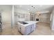 Open kitchen layout with center island, gray cabinetry, and view into the adjacent living area at 11621 La Mirago Pl, Las Vegas, NV 89138