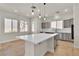 Kitchen island featuring a cooktop, modern pendant lights, and counter seating at 11621 La Mirago Pl, Las Vegas, NV 89138