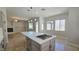 Bright, modern kitchen with large island, cooktop, and stainless appliances, open to the living area at 11621 La Mirago Pl, Las Vegas, NV 89138