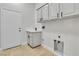 Laundry room with tile floors, white walls, cabinets, and a sink at 11621 La Mirago Pl, Las Vegas, NV 89138