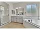 Bright main bathroom features a soaking tub, tiled floors, and a glass shower at 11621 La Mirago Pl, Las Vegas, NV 89138