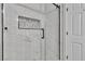 Shower with white and grey tile surround, glass enclosure, and black hardware at 11621 La Mirago Pl, Las Vegas, NV 89138