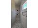 Tiled walk-in shower featuring river rock floor and accent wall niche at 11621 La Mirago Pl, Las Vegas, NV 89138