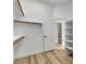 Bright walk-in closet featuring custom shelving, wood floors, and easy access to the Primary bath at 11621 La Mirago Pl, Las Vegas, NV 89138