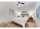 A cozy bedroom with white walls, wood flooring, neutral bedding, and natural light from a window at 11895 Skyline Arch Ct, Las Vegas, NV 89138