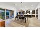 Open-concept dining area with stylish chandelier, wood floors, and access to the outdoor space and kitchen at 11895 Skyline Arch Ct, Las Vegas, NV 89138