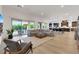 Bright and airy living room featuring a large sectional sofa, light wood floors, and access to outdoor patio at 11895 Skyline Arch Ct, Las Vegas, NV 89138