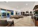 Open living area with a sectional sofa, modern decor, and large windows for natural light and view of the pool at 11895 Skyline Arch Ct, Las Vegas, NV 89138