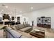 Comfortable living space featuring a sectional sofa, wood floors, and seamless flow into the dining and kitchen areas at 11895 Skyline Arch Ct, Las Vegas, NV 89138