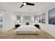 Bright bedroom with ample natural light, neutral decor, and a ceiling fan, and a door leading to the bathroom at 11895 Skyline Arch Ct, Las Vegas, NV 89138
