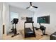 Bright workout room with exercise equipment and a ceiling fan with natural light from the windows at 11895 Skyline Arch Ct, Las Vegas, NV 89138