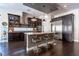 Modern kitchen featuring dark wood cabinets, granite countertops, an island, and stainless steel appliances at 125 Mirage View Dr, Henderson, NV 89011