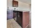 Island with stainless steel dishwasher, dark wood cabinets, and stone countertop at 1309 Dorothy Ave # 4, Las Vegas, NV 89119