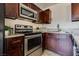 Close-up of stainless steel oven and dark wood cabinets with stone countertops and backsplash at 1309 Dorothy Ave # 4, Las Vegas, NV 89119