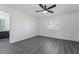 Bright bedroom showcasing gray wood-look flooring, neutral walls, ceiling fan, and a view into the bathroom at 1316 Eagle Meadow Ct, Las Vegas, NV 89123