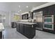 Spacious kitchen with an island, stainless steel appliances, dark cabinetry, and natural light at 1316 Eagle Meadow Ct, Las Vegas, NV 89123