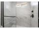 Sleek glass shower featuring marbled tile and modern fixtures, offering a spa-like experience at home at 1316 Eagle Meadow Ct, Las Vegas, NV 89123