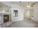Bright living room featuring a stone fireplace, ceiling fan, and neutral carpet at 1351 Fawn St, Pahrump, NV 89048