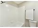 Bathtub and toilet featuring a white tile wall and showerhead at 1724 Navajo Lake Way, Las Vegas, NV 89128
