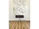 Modern fireplace with marble accent wall and wood floors at 1724 Navajo Lake Way, Las Vegas, NV 89128