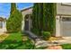 Charming two-story home with manicured lawn, lush green landscaping, and attached two-car garage at 1724 Navajo Lake Way, Las Vegas, NV 89128