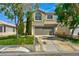 Inviting two-story home boasting a two-car garage, well-kept lawn, and mature trees providing shade at 1724 Navajo Lake Way, Las Vegas, NV 89128
